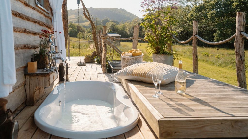 Relaxing in the Outdoor Bath at golden hour, Luxury Glamping Cabin, Carmarthenshire, West Wales