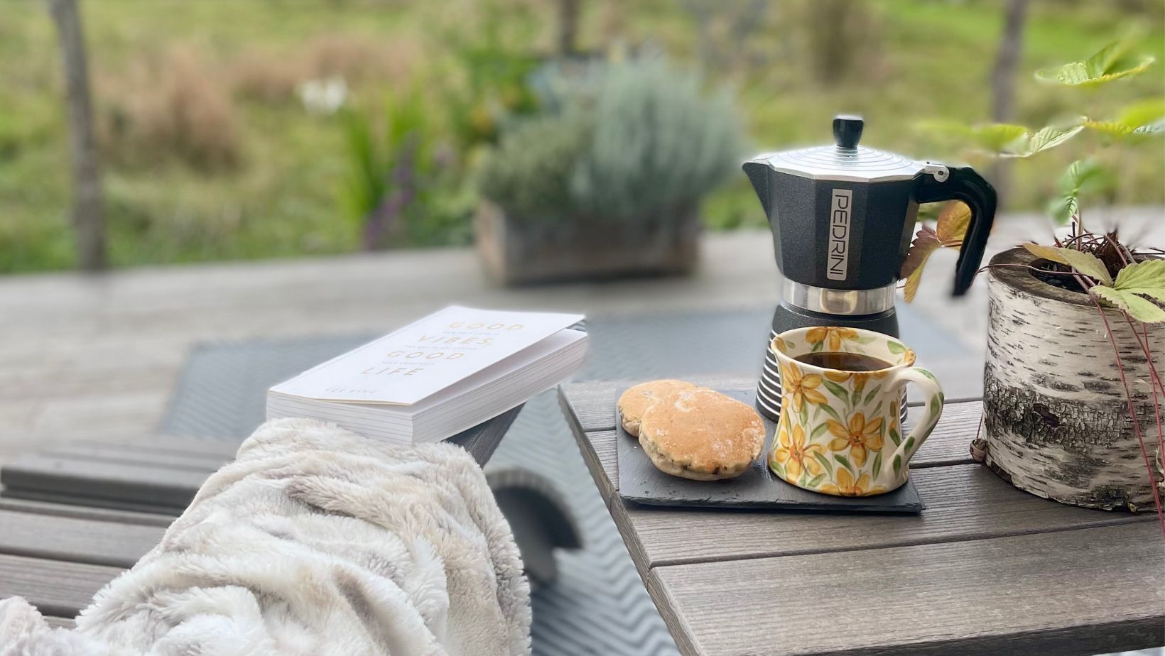 Relaxing on decking with a morning coffee overlooking the meadow - Luxury Glamping Cabin, Carmarthenshire, West Wales